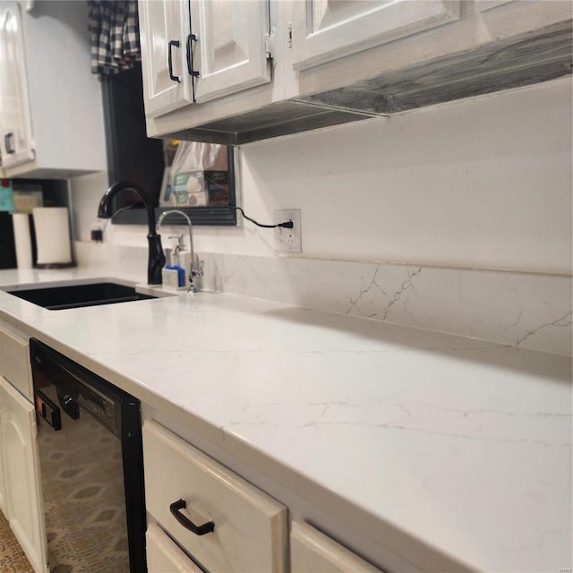 kitchen featuring light stone countertops, dishwasher, and sink