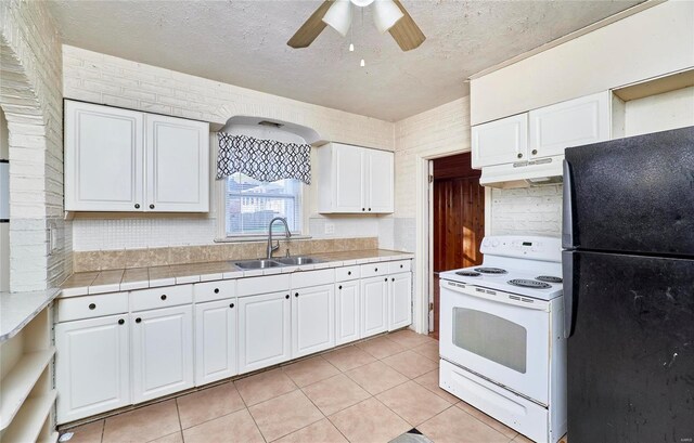 kitchen featuring black refrigerator, sink, white range with electric cooktop, white cabinets, and ceiling fan