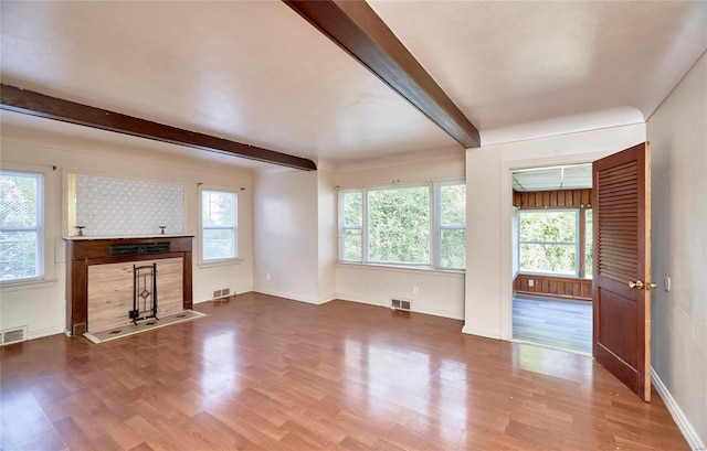 unfurnished living room with beam ceiling and hardwood / wood-style flooring