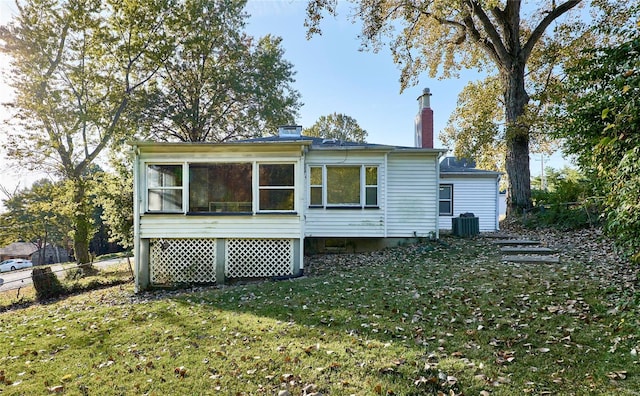 back of house featuring a yard, a sunroom, and central AC