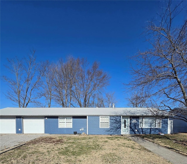 single story home featuring driveway, a front yard, and a garage