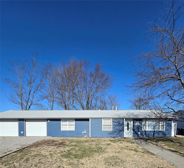 single story home with an attached garage, driveway, and a front lawn