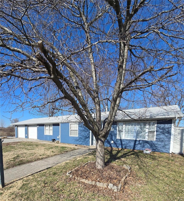 ranch-style house featuring an attached garage and a front lawn