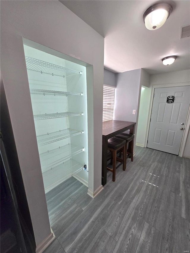 interior space featuring visible vents, baseboards, and wood finished floors