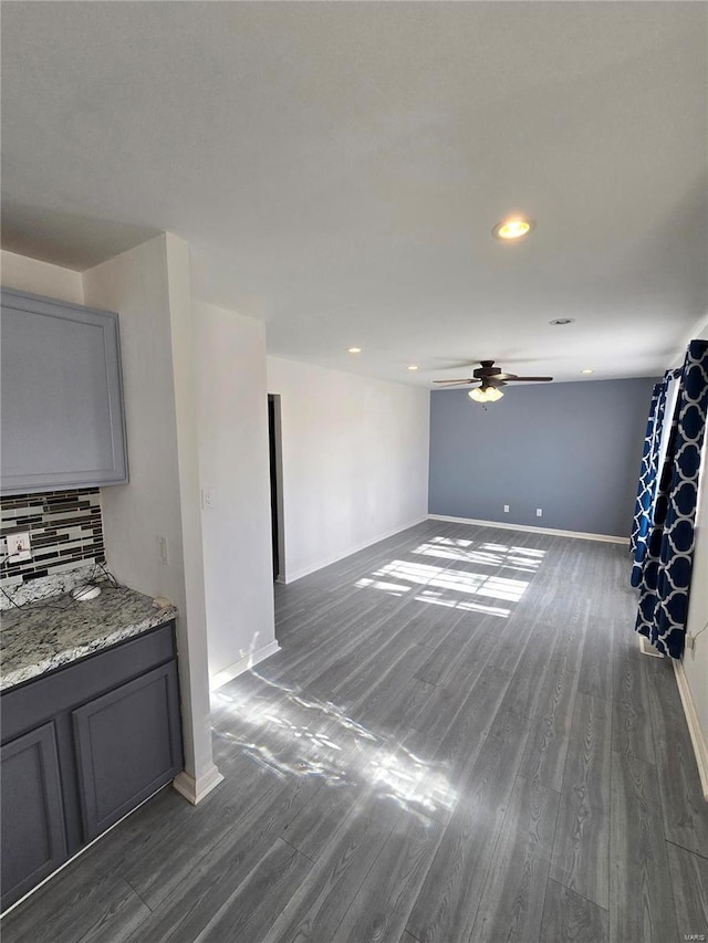 empty room featuring recessed lighting, baseboards, dark wood-type flooring, and a ceiling fan