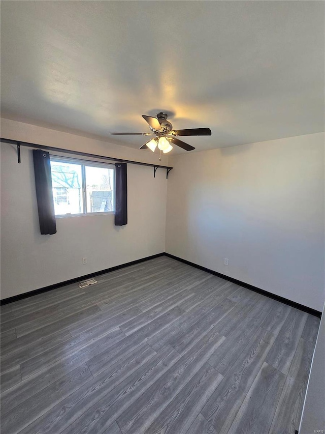 unfurnished room featuring visible vents, ceiling fan, baseboards, and wood finished floors