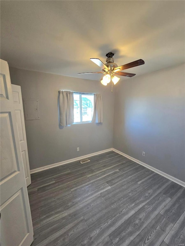 unfurnished room with dark wood-type flooring, baseboards, visible vents, and ceiling fan