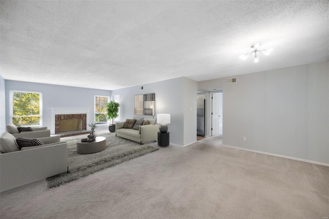 living room featuring a chandelier, a textured ceiling, light colored carpet, and a fireplace