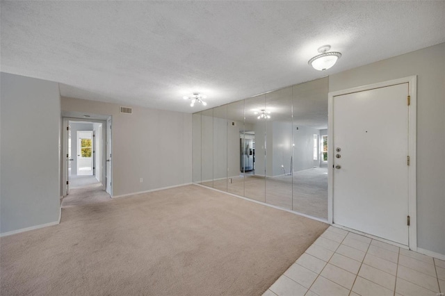 carpeted spare room featuring a textured ceiling