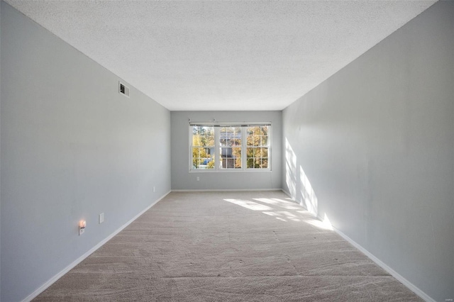 carpeted spare room with a textured ceiling