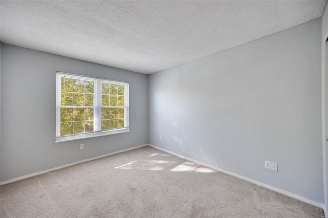 unfurnished room with a textured ceiling and light carpet