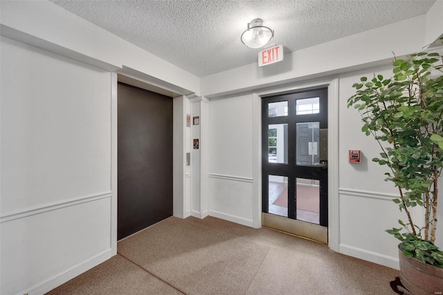 interior space featuring elevator and a textured ceiling