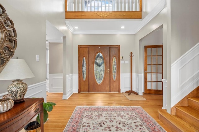 foyer entrance featuring light hardwood / wood-style floors and ornamental molding