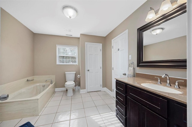 bathroom featuring tile patterned floors, a tub to relax in, vanity, and toilet