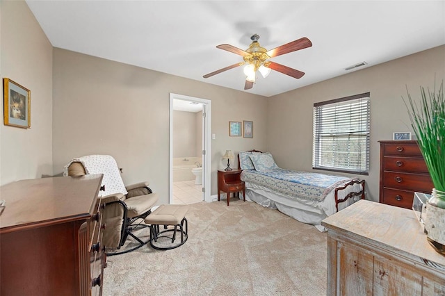 bedroom featuring ensuite bath, ceiling fan, and light carpet