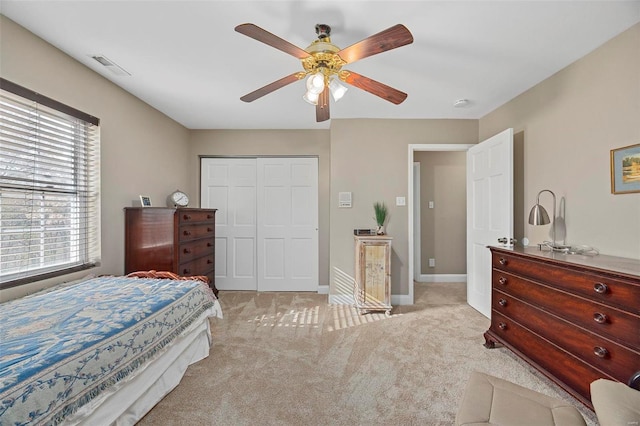 bedroom featuring ceiling fan, a closet, and light carpet