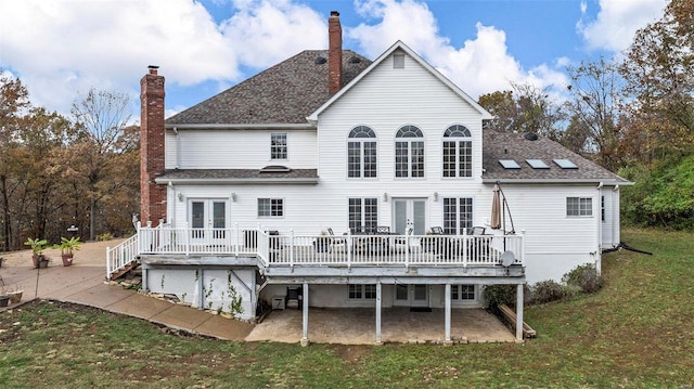 rear view of house with french doors, a yard, and a wooden deck