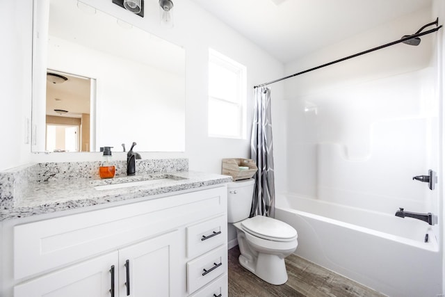 bathroom with shower / bath combo, vanity, toilet, and wood finished floors