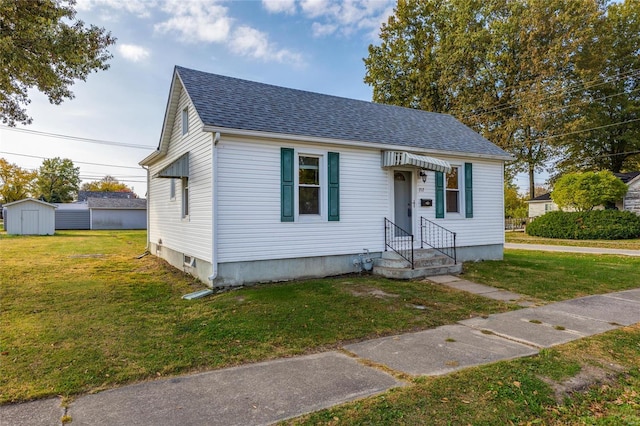 bungalow-style house featuring a front yard and a storage unit