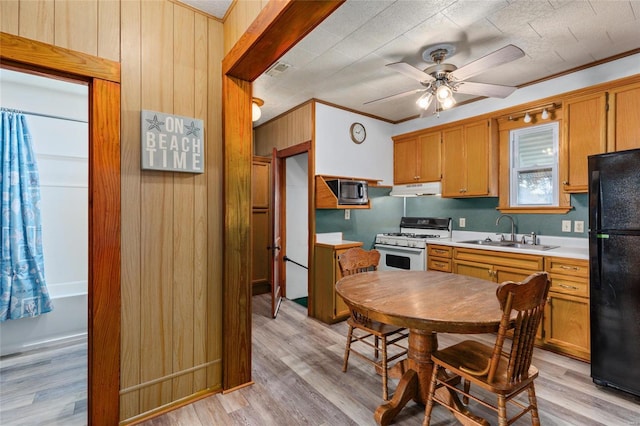 kitchen with light hardwood / wood-style floors, white gas stove, sink, and black refrigerator