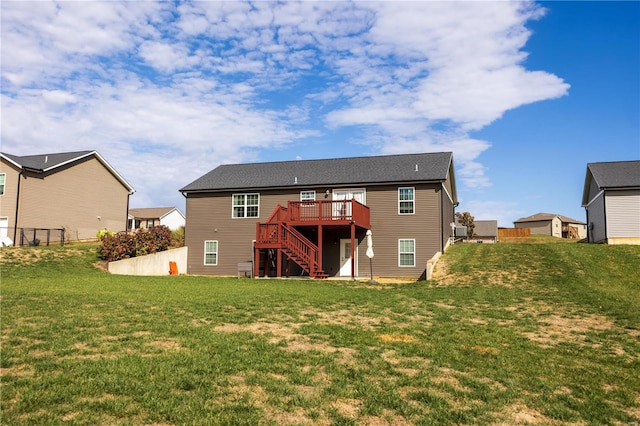 rear view of property featuring a wooden deck and a lawn