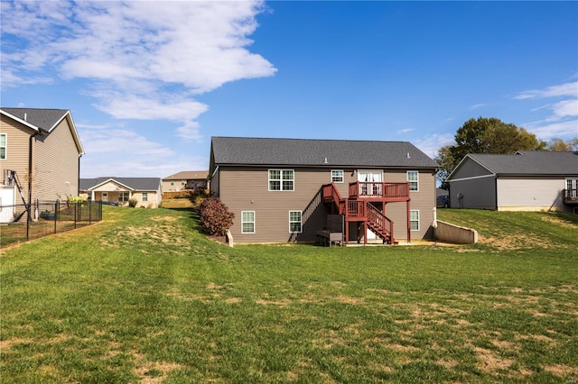 back of property featuring a wooden deck and a lawn