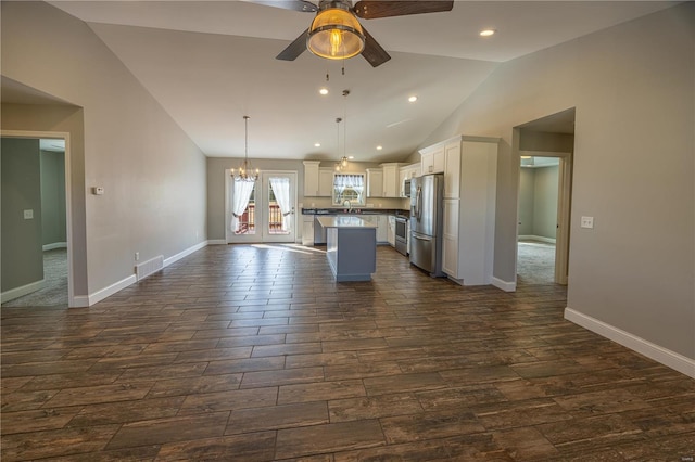 kitchen with a kitchen island, pendant lighting, white cabinetry, appliances with stainless steel finishes, and ceiling fan with notable chandelier