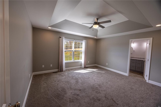 unfurnished room featuring light carpet, a raised ceiling, and ceiling fan