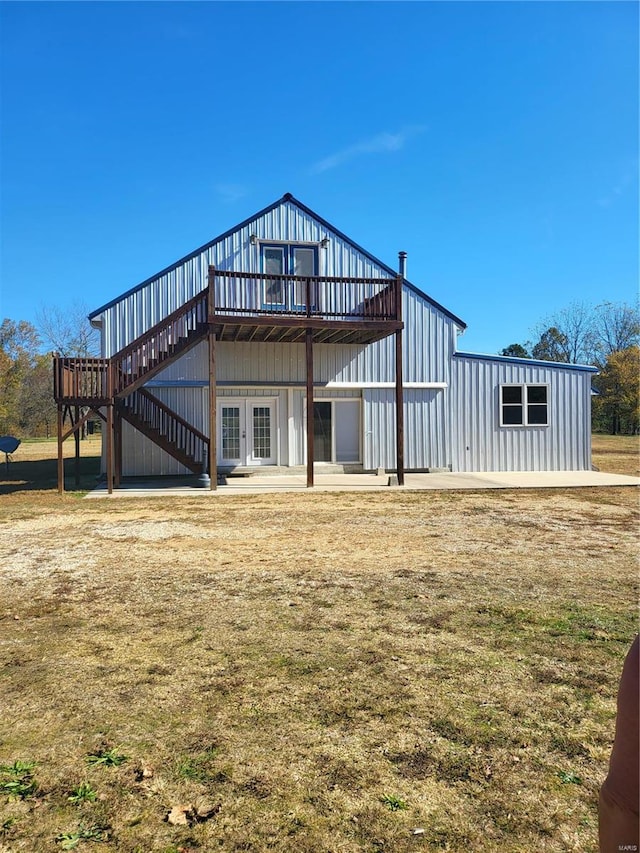 rear view of property with a wooden deck, french doors, and a yard