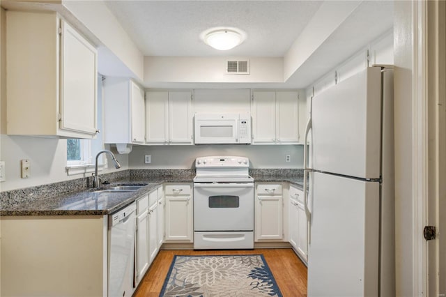 kitchen featuring white cabinetry, sink, a textured ceiling, white appliances, and light hardwood / wood-style flooring