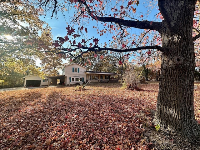 view of front facade featuring covered porch, a garage, and a carport