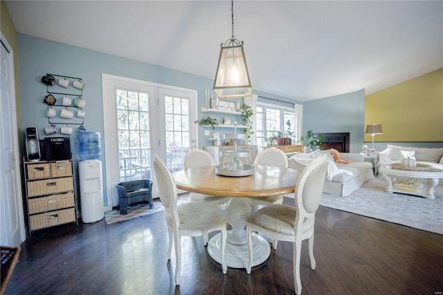 dining area featuring dark hardwood / wood-style floors, a healthy amount of sunlight, and vaulted ceiling