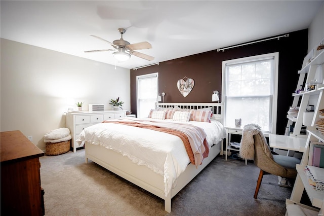 carpeted bedroom featuring ceiling fan and multiple windows