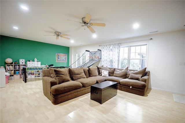 living room with light hardwood / wood-style floors and ceiling fan