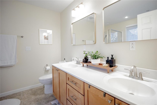 bathroom with toilet, vanity, and tile patterned flooring