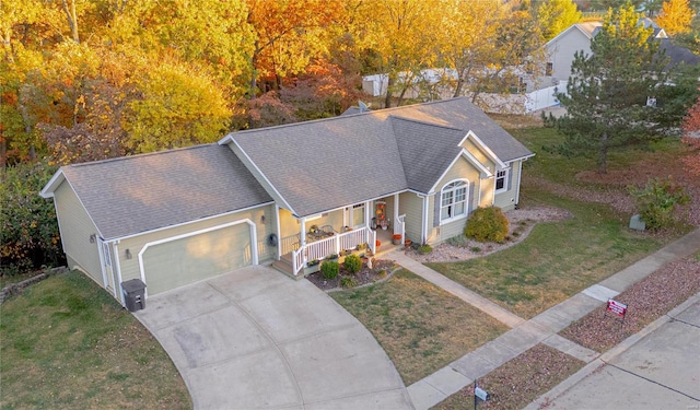 view of front facade with a front lawn, covered porch, and a garage