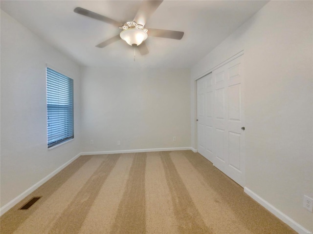 unfurnished bedroom featuring a closet, carpet, and ceiling fan