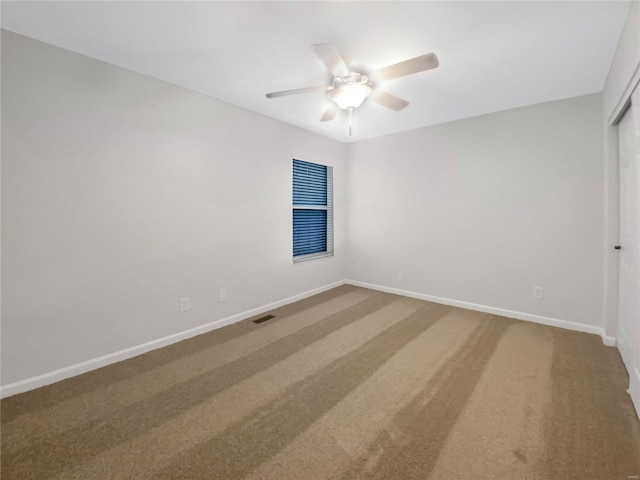 carpeted spare room featuring ceiling fan