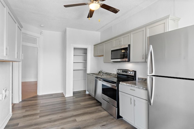 kitchen with gray cabinets, a textured ceiling, stainless steel appliances, and hardwood / wood-style flooring