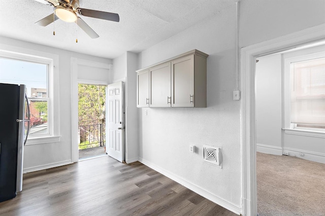 kitchen featuring gray cabinets, a textured ceiling, dark hardwood / wood-style floors, and stainless steel refrigerator