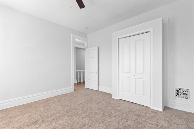 unfurnished bedroom featuring carpet, a closet, and ceiling fan