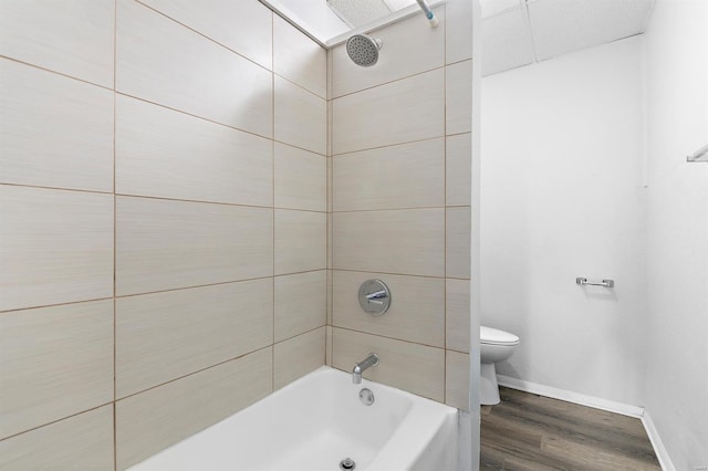 bathroom featuring tiled shower / bath, wood-type flooring, and toilet