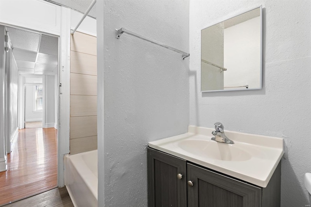 bathroom featuring vanity, washtub / shower combination, and wood-type flooring