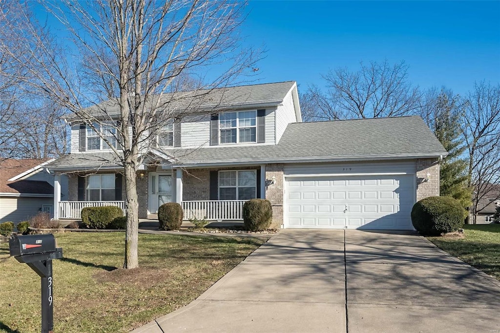 view of property featuring covered porch, a front lawn, and a garage