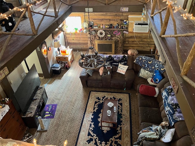 carpeted living room featuring wood walls, a chandelier, and a wall unit AC