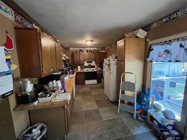 kitchen featuring white appliances, sink, and dark tile patterned floors