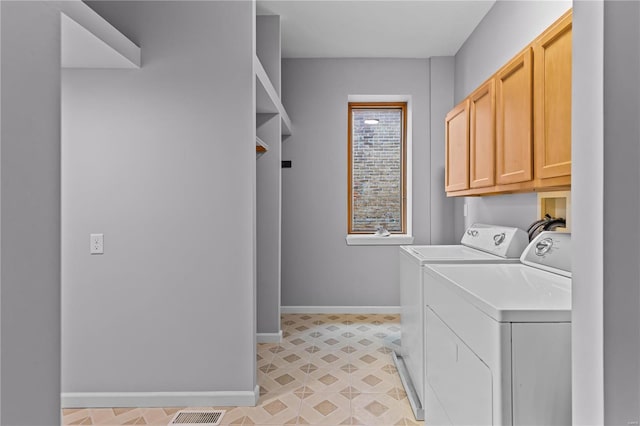 laundry room with washer and dryer and cabinets