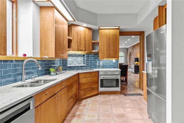 kitchen featuring sink, stainless steel appliances, tasteful backsplash, light stone counters, and light tile patterned floors