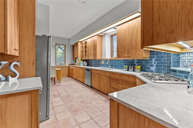 kitchen with light tile patterned flooring, appliances with stainless steel finishes, tasteful backsplash, and sink