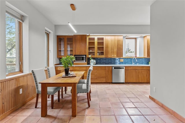 kitchen featuring appliances with stainless steel finishes, backsplash, sink, hanging light fixtures, and light tile patterned flooring